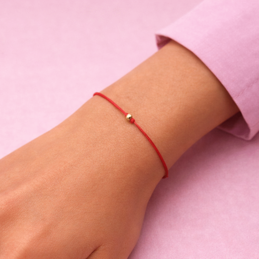 Bransoletka na czerwonym sznureczku na szczęście z pozłacaną grawerowaną kulką
